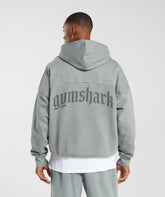 رجل يرتدي هوديي رمادي ثقيل الوزن من تصميم كلاسيكو مع كلمة Gymshark | يونايتد نحن نتعرق عليه.